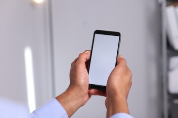 African-american man using smartphone in office, closeup