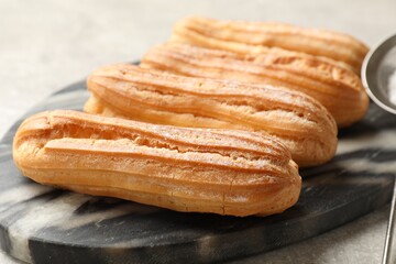 Delicious eclairs on light grey table, closeup