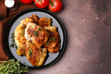 Tasty cooked chicken thighs with thyme and tomatoes on brown table, flat lay. Space for text