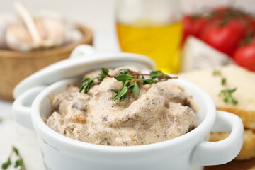Tasty beef Stroganoff with thyme in casserole and ingredients on table, closeup