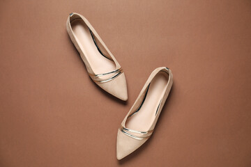 Pair of stylish shoes on brown background, top view