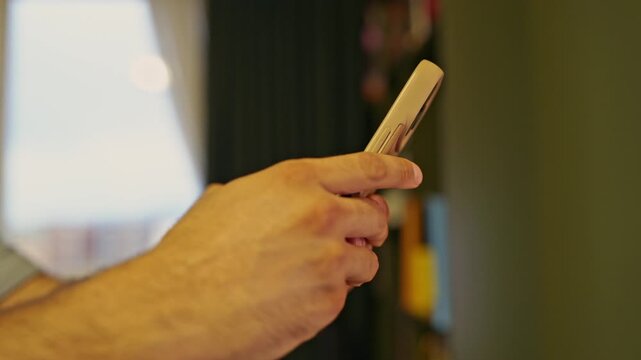 A person's hand uses a remote control, pressing buttons to operate an electronic device with distinct clicking sounds. This close-up shot captures the routine action of technology interaction.