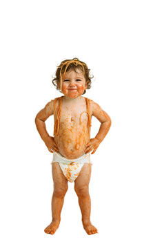 A toddler covered in spaghetti sauce looking proud