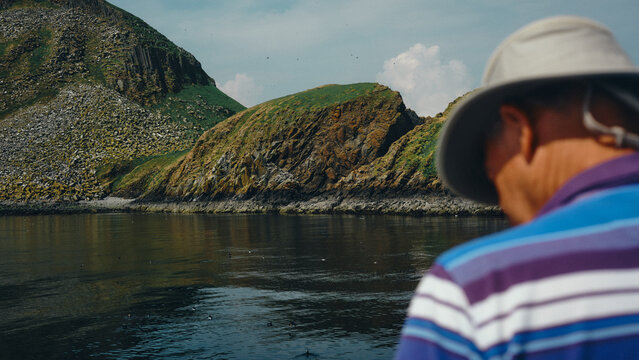man looking out to sea and cliff