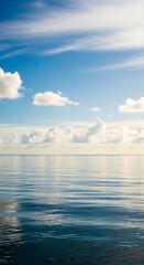 Obraz premium Serene Ocean Vista - Reflections of Sky and Clouds on Calm Waters.