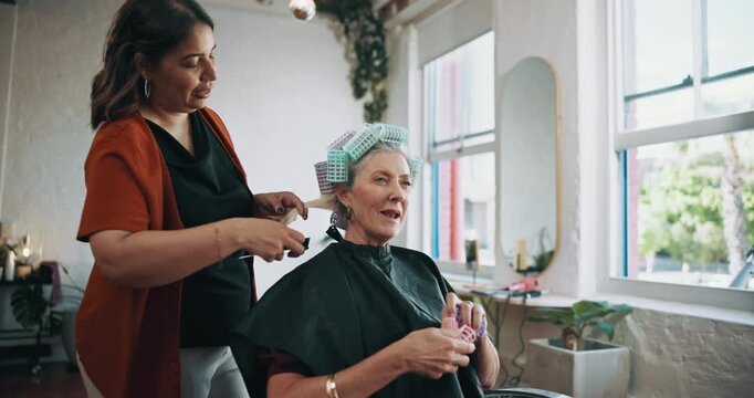 Old woman, hairdresser and hair rollers in beauty salon, curler or conversation. Hairstylist, tools or talking to customer for service, grooming or comb hairstyle with senior person in small business