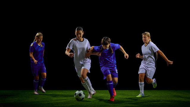 Teenage female soccer players competing for ball in dynamic midfield action. Concept of youth training programs, tactical education, match strategy materials, teamwork promotion.