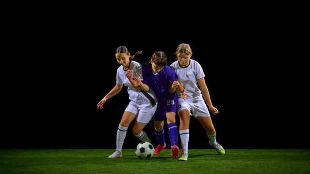 Teenage female soccer players battling tightly for ball in crowded duel. Concept of youth competition training, close-contact drills, tactical discipline, team strategy.