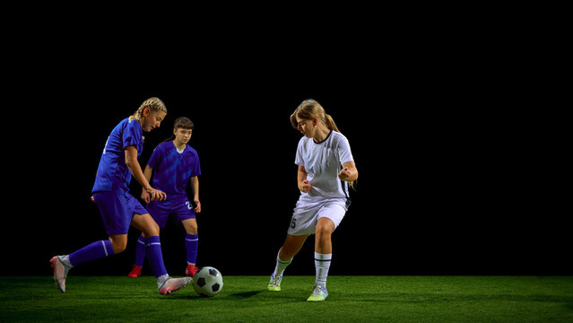 Teenage girls soccer players defending ball under pressure from opponents. Concept of youth tactical instruction, defensive coaching, possession retention drills, game analysis.