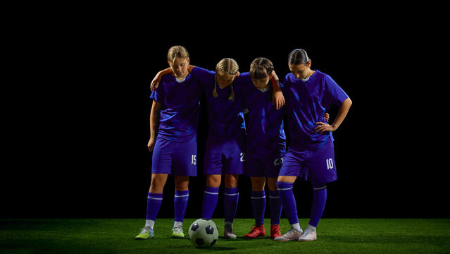 Teenage soccer team standing together in close huddle before match. Concept of youth teamwork, pre-game motivation, leadership building, sports education materials.