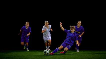 Teenage soccer players competing for ball with one athlete sliding in fast defensive action. Concept of youth tactical training, match-analysis materials, competitive drills, coaching content.