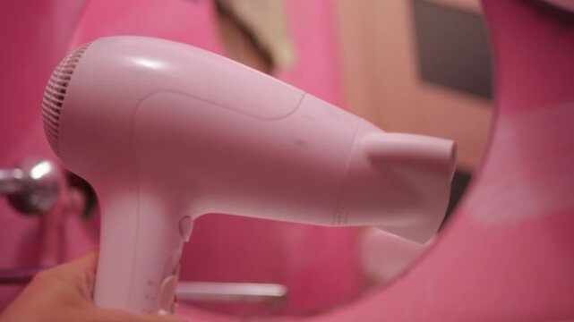 Hair Dryer Working Medium Fan Mode with Sound, Modern Bathroom Interior Pink Walls Background, Hair Styling Technology Device, Domestic Comfort Appliance Operation, Personal Care Routine