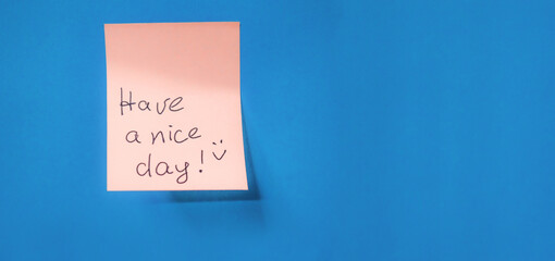 Orange aesthetic, background, blSticky note with handwritten message wishes someone. Have a nice day, placed against a bright blue background. The cheerful note adds a touch of positivity. Copy space.