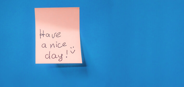 Orange aesthetic, background, blSticky note with handwritten message wishes someone. Have a nice day, placed against a bright blue background. The cheerful note adds a touch of positivity. Copy space.