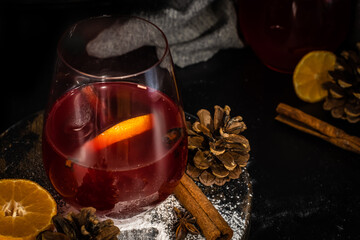 Mulled wine with citrus and spices in rustic winter setting