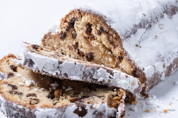 Traditional Christmas Stollen with Raisins and Powdered Sugar isolated on white background. Close up