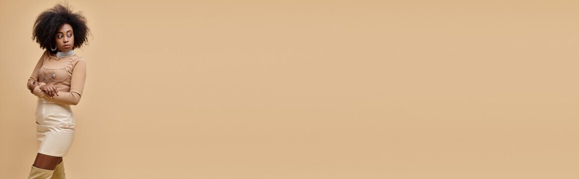 Young woman in beige outfits showcases vibrant fashion in studio setting