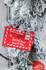 a vertical shot of a red santa claus hanging on a christmas tree