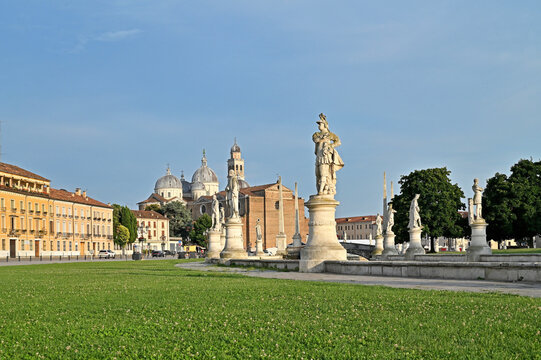 Padua, Italy. Pratto della Valle square with two rows of statues (late 18th century), an oval-shaped canal, and bridges. The Basilica of Santa Giustina is in the background.