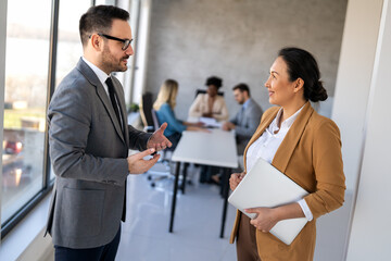 Multicultural professional businesspeople working together on research plan in boardroom.