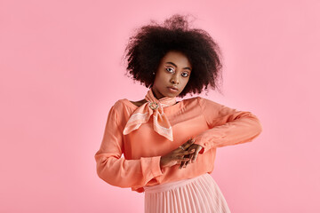 Curly young woman in vibrant pink attire showcasing unique style in studio setting
