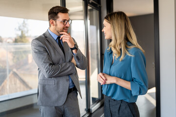 Professionals in a modern office environment discussing work-related matters