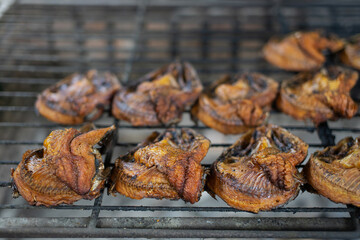 Several grilled fish on a metal grill, close-up photo.