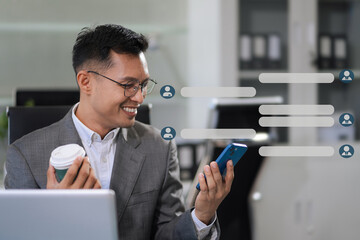 Businessman using mobile phone play social media and enjoying coffee in office.
