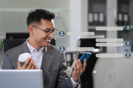 Businessman using mobile phone play social media and enjoying coffee in office. - Powered by Adobe