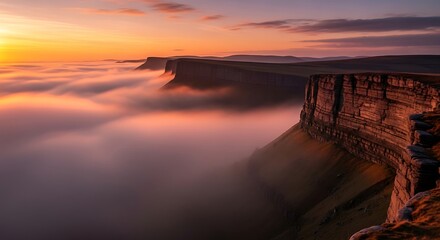 Majestic cliffs rise above a sea of fog at sunset, creating a breathtaking landscape.