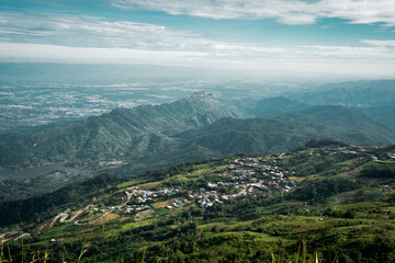 Fototapeta premium Beautiful mountain landscape with sea of mist, winding road, and resorts at Phu Thap Boek, Thailand.