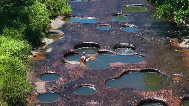 woman enjoying a relaxing bath in the natural pools of Las Gachas River in Colombia