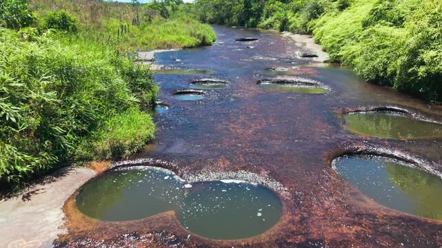 Aerial view of a blonde woman swimming in the natural jacuzzis of las gachas river in colombia