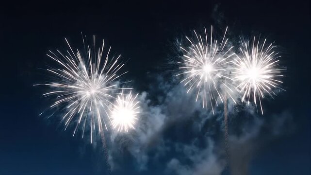 Fireworks display against a dark blue sky, streaks of light creating various shapes