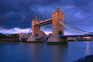 Obraz premium Tower Bridge, the iconic landmark of London spanning the River Thames, captured in a romantic moment. The elegant structure, illuminated against the water.