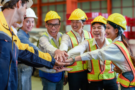 Group of young Engineer United stack hands or join hand teamwork together with Spirit diversity solidarity team Partner in metal sheet factory. Joins hands together teamwork meetings empower.