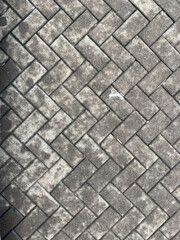 brick paving texture on flat lay view. Grey concrete pavers with weathered stains. geometric background ideal for architecture mockups, product backdrops, and design textures.