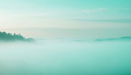 Fototapeta premium Misty landscape with trees in the distance, soft turquoise tones.