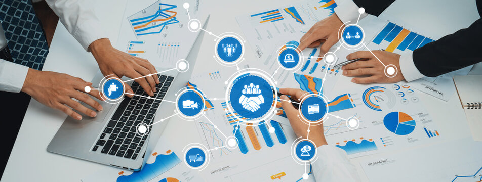 A professional team collaborates during a business meeting, analyzing data charts and utilizing laptops to strategize and discuss key insights for project success. Amity
