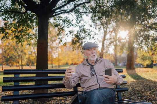 Senior man relaxing on park bench in autumn