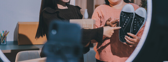 Asian woman describe selling clothes on camera live broadcast on social network at home, Online...