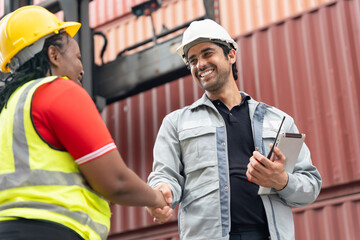 Engineer and dock worker shaking hands at cargo container, Smiling industrial professionals...