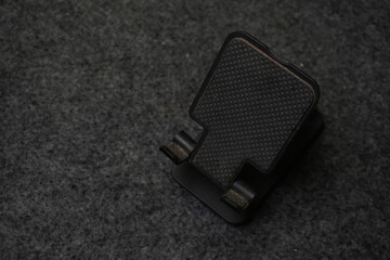Black Foldable Mobile Phone Holder on Textured Surface
