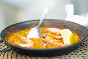 A close-up shot of Spanish seafood paella, featuring giant prawns on rice