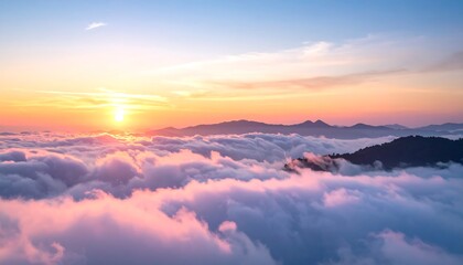 Dawn sunlight over mountains blanketed by fluffy clouds with pink and orange hues in the sky