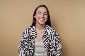 Happy woman in zebra print jacket smiles against a warm background in a bright indoor setting © bodnarphoto