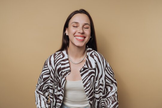 Happy woman in zebra print jacket smiles against a warm background in a bright indoor setting
