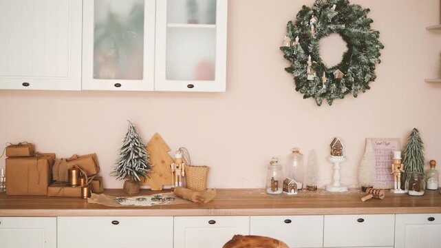 Kitchen counter display of holiday gifts, pine trees and nutcracker decoration with festive wreath