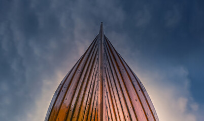 Low Angle View of Wooden Viking Longship Prow Against Dramatic Cloudy Sky