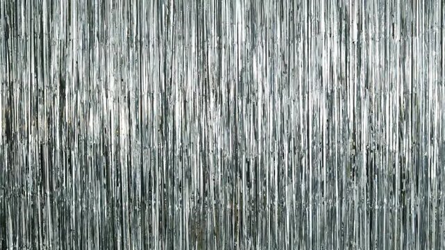 Shiny metallic fringe backdrop curtains shimmering with light, a festive party decoration